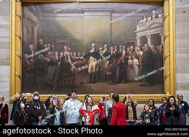 Tourists stand under a painting €œGeneral George Washington Resigning His Commission€ in the US Capitol Rotunda. 19 people in this painting have been...