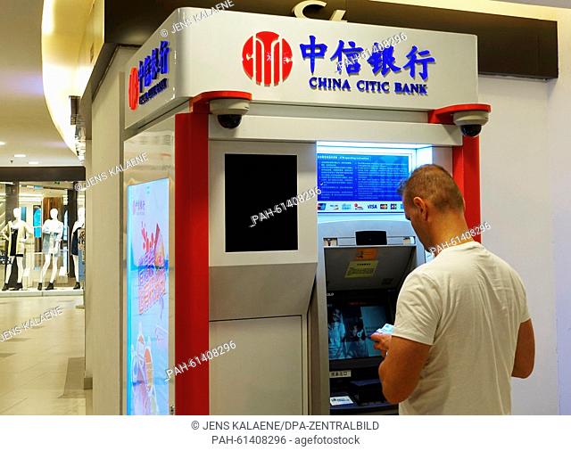 A man withdraws money from an ATM in Shanghai,  China, 30 August 2015. Photo: Jens Kalaene/dpa | usage worldwide. - Shanghai/China