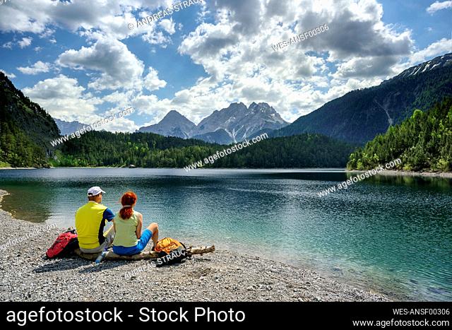 Austria, Tyrol, Hiking couple relaxing on shore of Blindsee