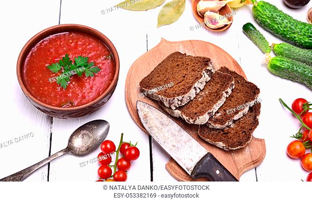 Gazpacho spanish cold soup in a round ceramic plate and bread, top view