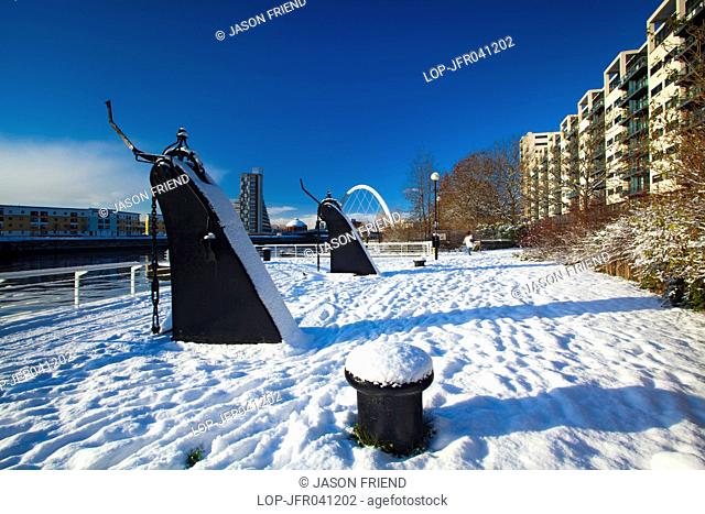 Scotland, City of Glasgow, Glasgow. View over the Clyde Quayside redevelopment area covered in snow towards Glasgow's Clyde Arc bridge