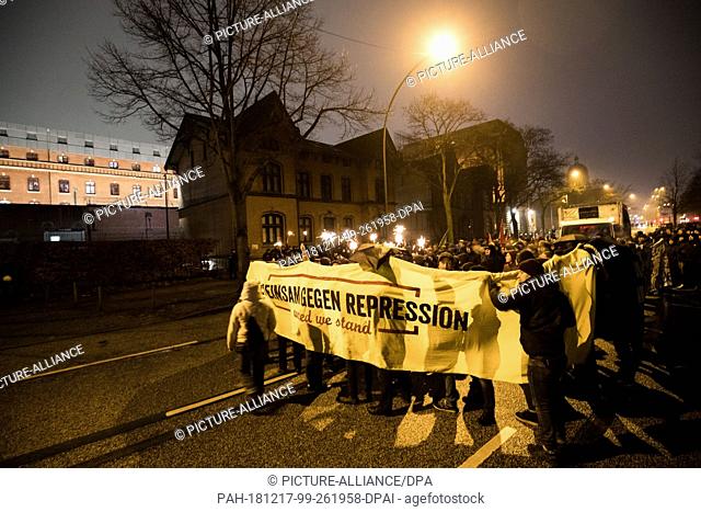 17 December 2018, Hamburg: Participants of a demonstration ""Together Against Repression"" protest against a G20 trial in front of the remand prison next to the...