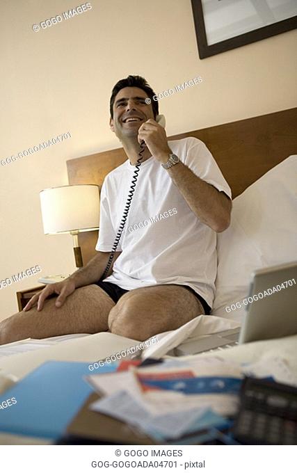 Businessman talking on phone in hotel room