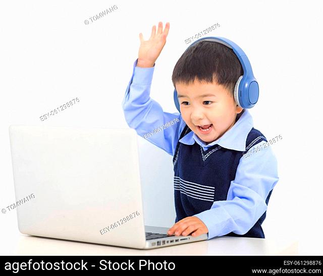 Happy kid boy doing homework project on laptop