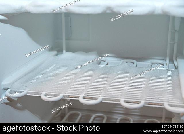 vereister Gefrierschrank - Nahaufnahme Kühllamellen eines Tiefkühlschrankes mit Eisbelag