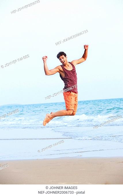 Young man jumping on beach
