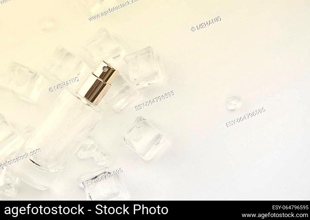 Female perfume bottle, objective photograph of perfume bottle in ice cubes and water. view from above. product photo, concept of freshness