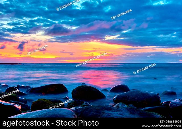 The sea and stones on the shore at sundown - Sunset seascape. Tenerife, The Canaries