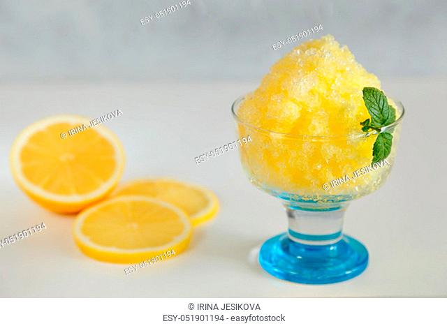Japanese dessert kakigori lemon in a glass bowl and lemon slices in the background