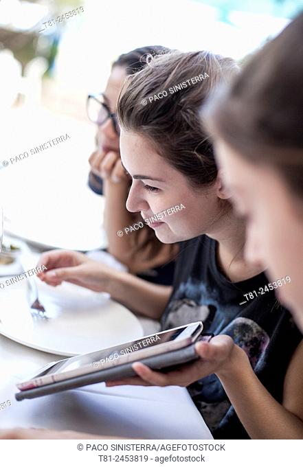 girls looking at a tablet in Benidorm, Spain