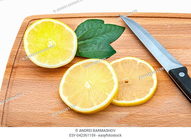 On the cutting board are a few slices of fresh lemon and a knife