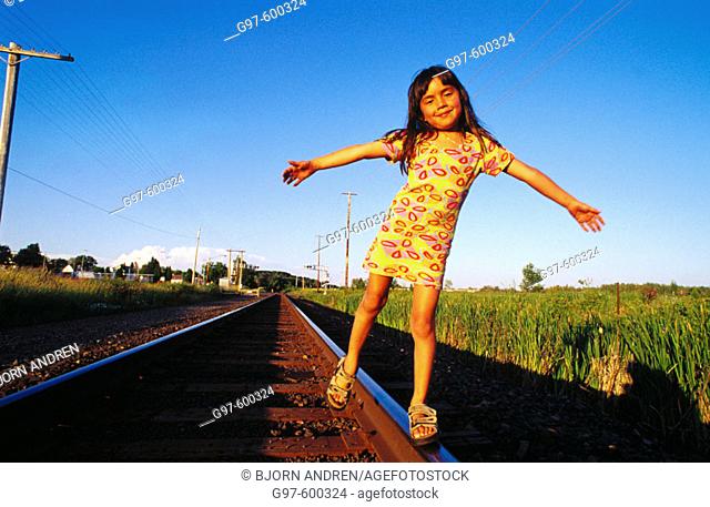Girl, 6 years old, balancing on railroad track