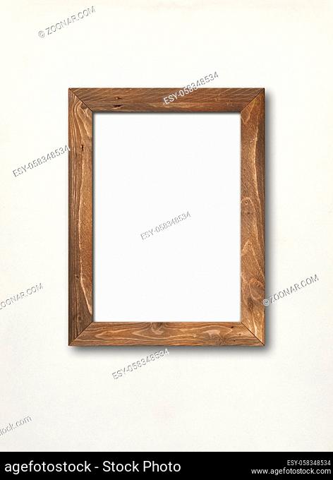 Old brown rustic wooden picture frame hanging on a white wall. Blank mockup template