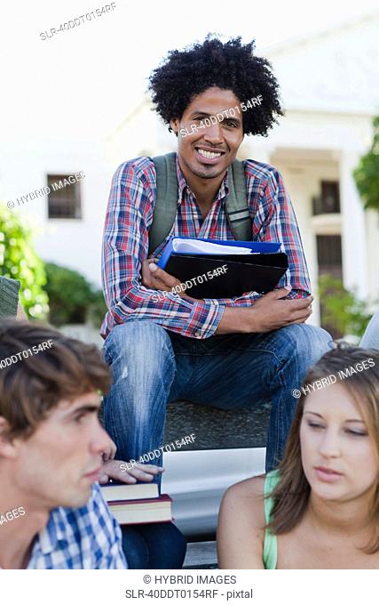 Man sitting with colleagues on campus