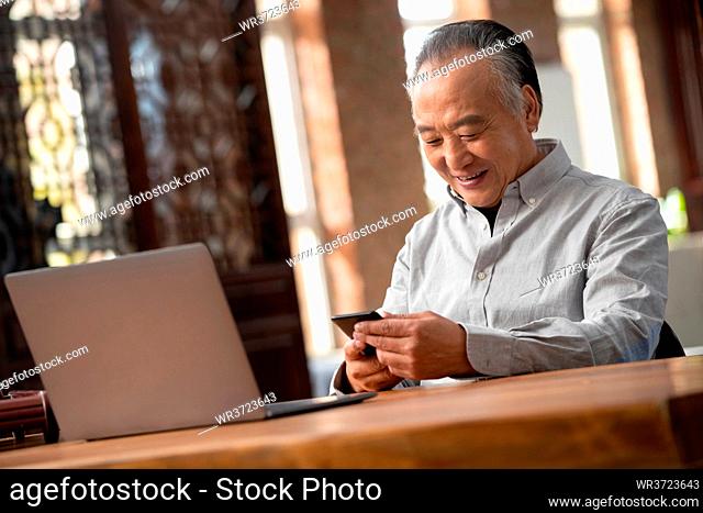 The elderly using a cell phone at home