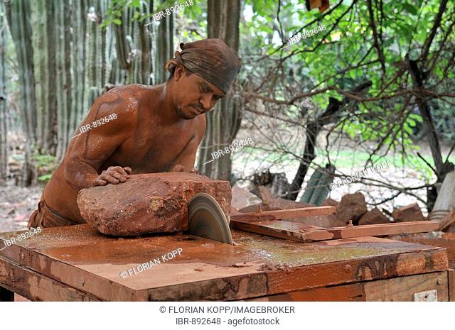 Craftsman with exposed torso cutting pieces of steatite or soapstone with a circular saw, San Juan de Limay, Nicaragua, Central America