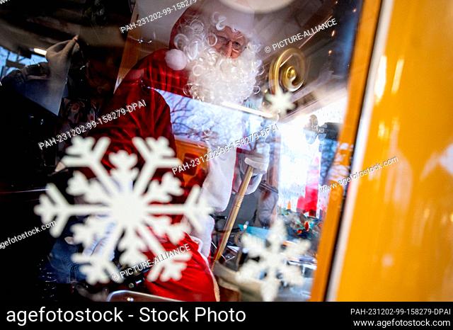 02 December 2023, Berlin: A man in a Santa Claus costume stands in the Christmas train of the Historische S-Bahn association