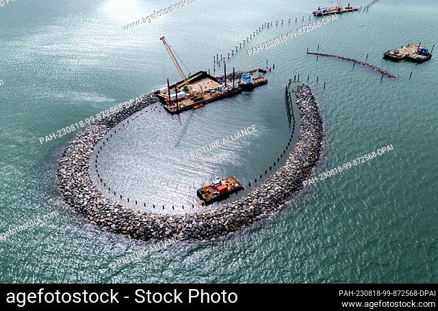 PRODUCTION - 10 August 2023, Mecklenburg-Western Pomerania, Prerow: Cranes standing on pontoons are used to assemble the concrete structures for the new island...