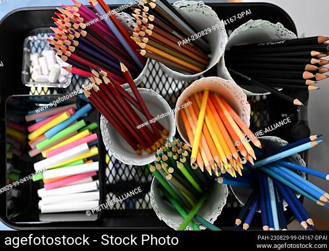PRODUCTION - 29 August 2023, Hesse, Wiesbaden: Crayons and pencils as well as white and colored chalk are provided in a lending station in a classroom at Robert...