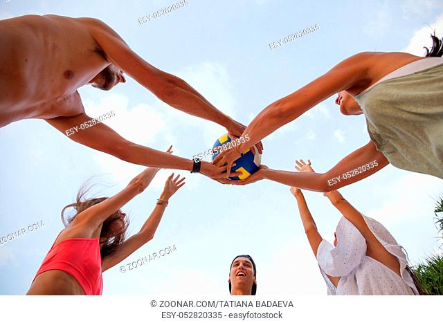 Group of young people playing volleyball outdoors