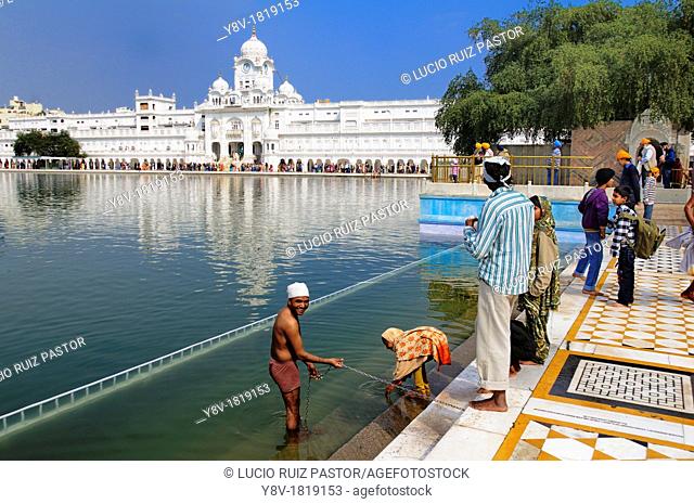 India. Punjab. Amritsar. The Golden Temple. The sacred pool Anrit Sarovar pool of the Nectar of Immortality, at the background the Parikrama Marble Path or...