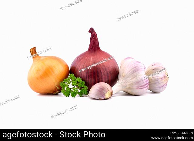 Garlic bulbs and cloves, green parsley twig, golden-brown and red onion isolated on white background