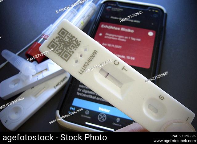 Topic image: Corona quick test after risk encounter (symbolic photo). The Corona Warn app on a smartphone indicates increased risk