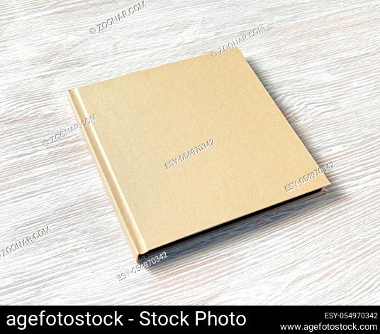 Closed blank square brochure on light wooden background