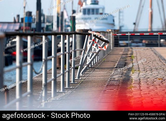 25 November 2020, Hamburg: A damaged railing on the quay wall at the museum harbour is cordoned off with fluttering tape from the police