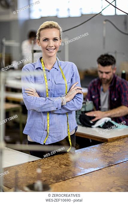 Portrait of smiling young woman in tailor shop