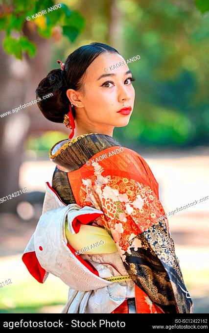 Portrait of woman wearing kimono standing in park