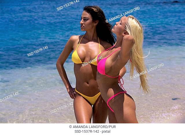Two young women standing on the beach