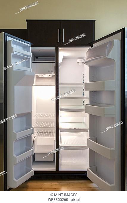 Open empty refrigerator in modern kitchen
