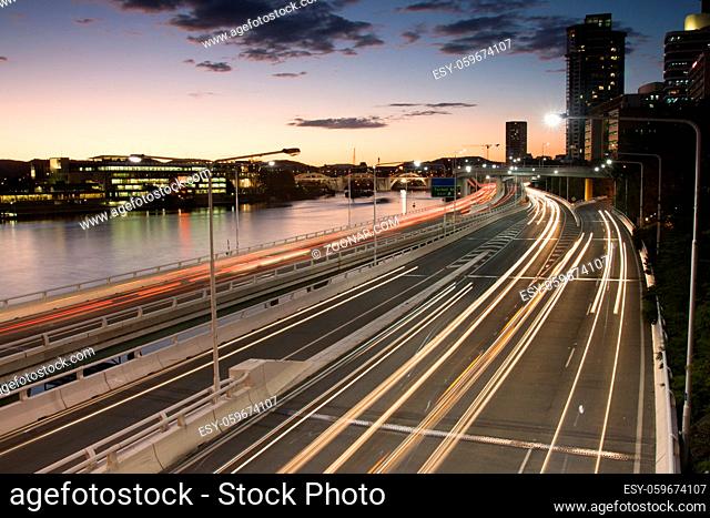 Traffic streams along the Pacific Motorway and Victoria Bridge during rush hour at dusk