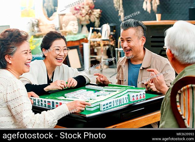 Happy old friends playing mahjong