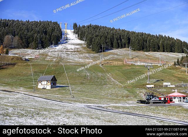 23 November 2021, Saxony, Oberwiesenthal: View of the still green ski slope on the Fichtelberg. Saxony's lift operators are anxiously looking ahead to the...