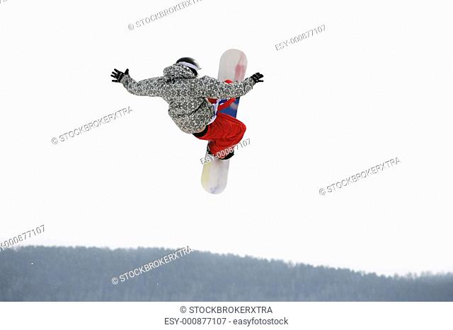 Image of courageous guy jumping on snowboarder in the air