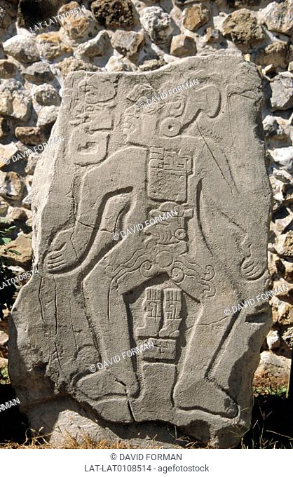 Ancient Zapotec archaeological site. The Gran Plaza temple and a close up of the Los Danzantes carved figure of a god on a stone slab