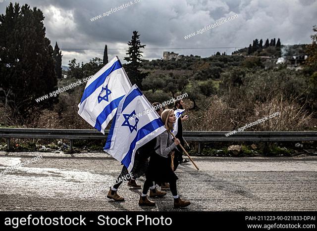 23 December 2021, Palestinian Territories, Nablus: Israeli right-wing activists and settlers take part in a protest march at the West Bank outpost of Homesh