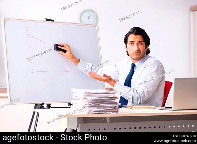 Young handsome financial speciaist in front of white board