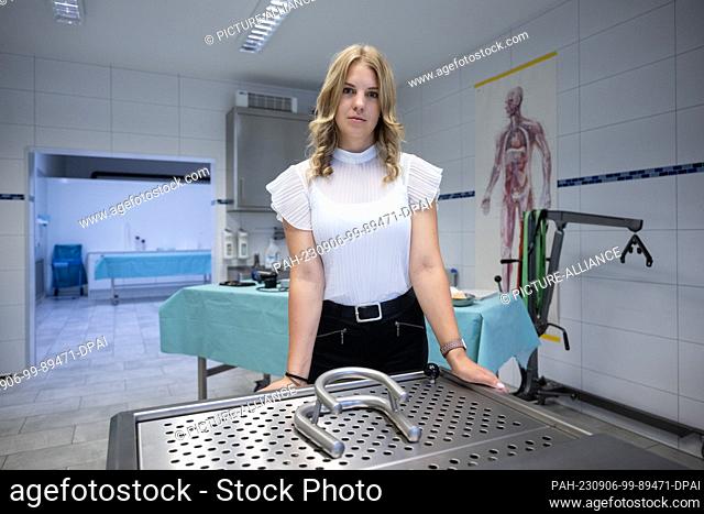 PRODUCTION - 16 August 2023, Baden-Württemberg, Geislingen an der Steige: Funeral director Emily Maichle stands behind a treatment table in the treatment room...