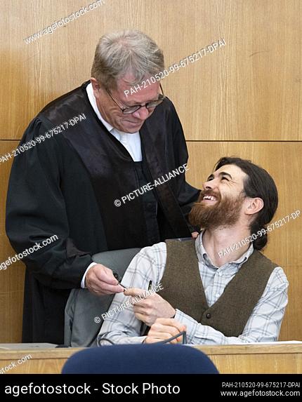 20 May 2021, Hessen, Frankfurt/Main: The defendant Franco A. jokes with his lawyer Johannes Hock (back) at the start of the trial in the dock in the high...