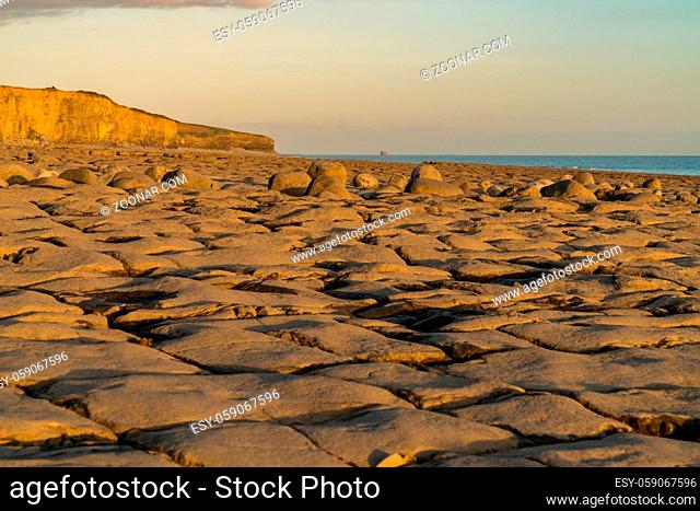 The stones and cliffs of Llantwit Major Beach in the evening sun, South Glamorgan, Wales, UK