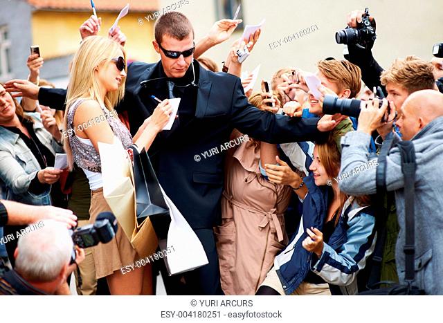Bodyguard trying to keep the public away from a pretty young celebrity