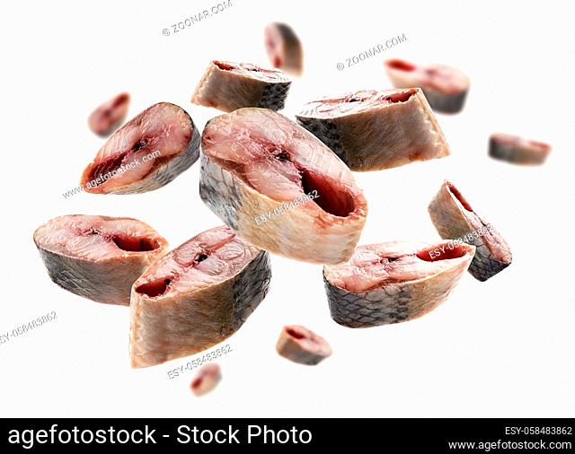 Pieces of fresh fish in the shape of a heart on a white background