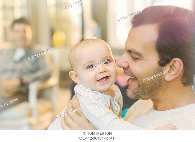 Portrait happy father holding cute baby son
