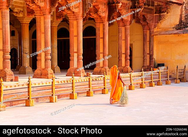 Local woman sweeping near Diwan-i-Am - Hall of Public Audience in Amber Fort, Rajasthan, India. Here the maharaja held audience and received the petitions of...