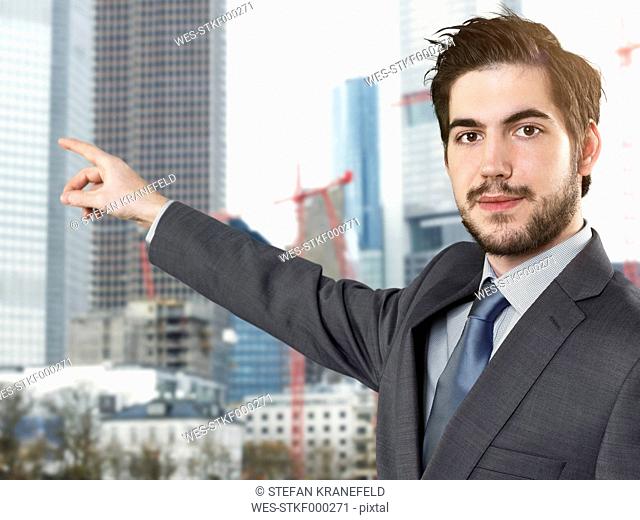 Portrait of young businessman pointing finger
