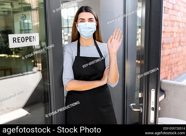 woman in mask with reopen banner on door glass