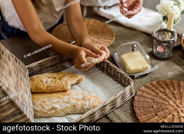 Girl breaking freshly baked ciabatta at home